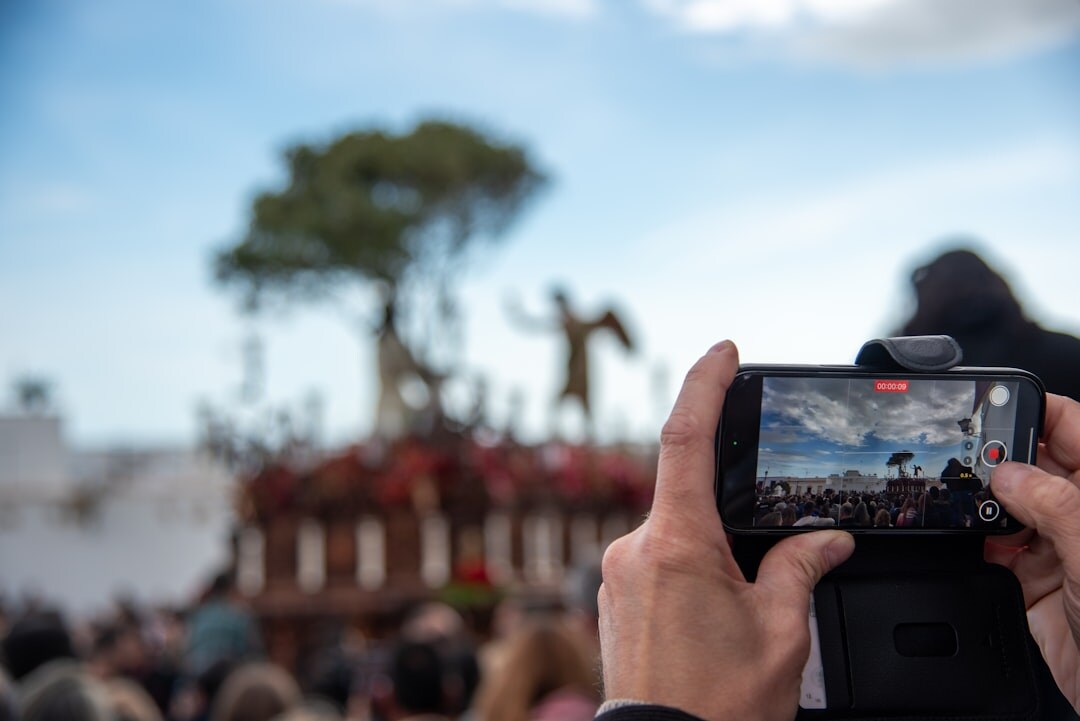 Hand holding a smartphone recording video outdoors for mobile journalism